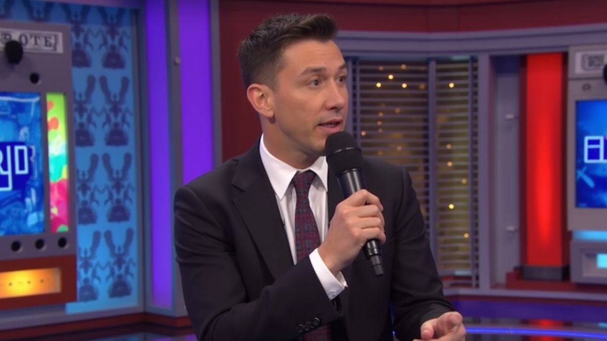 Wedstrijpresentator met een microfoon in een kleurrijke televisiestudio.