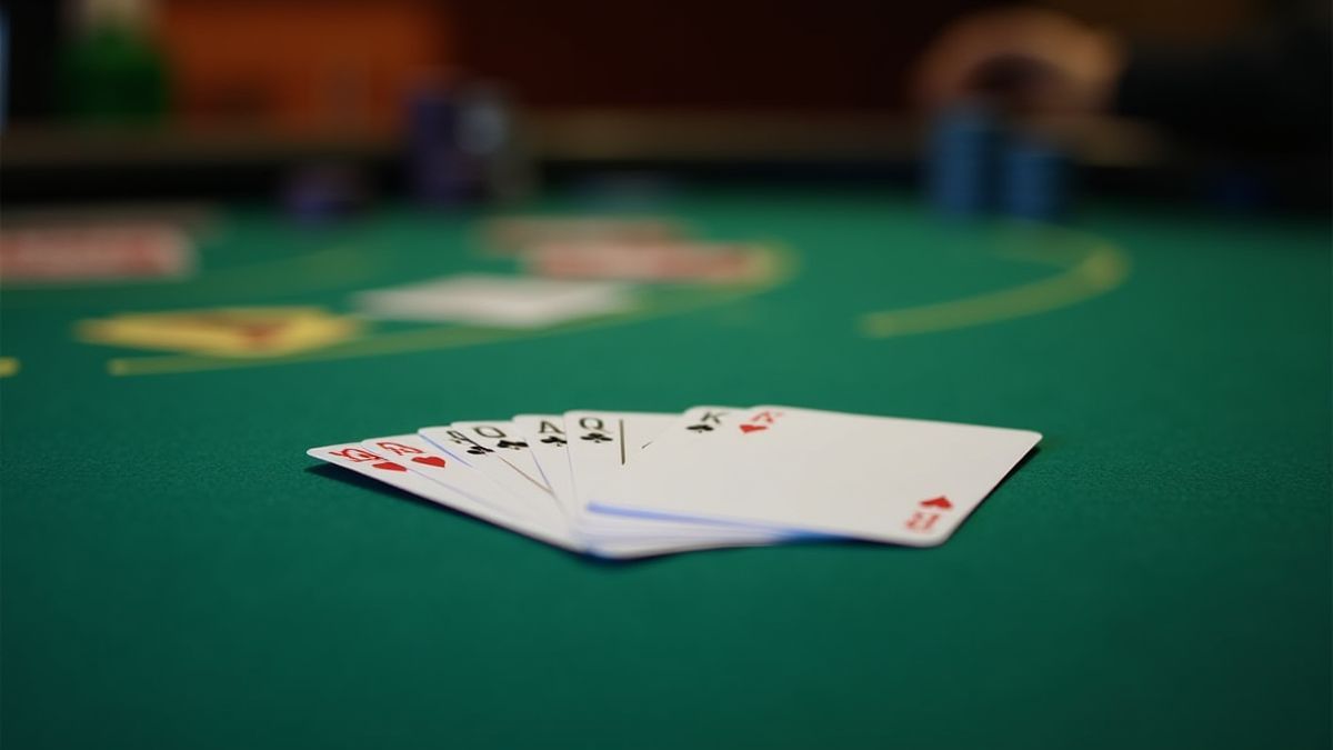 Mesa de pôquer verde com cartas e fichas organizadas sob luz suave.