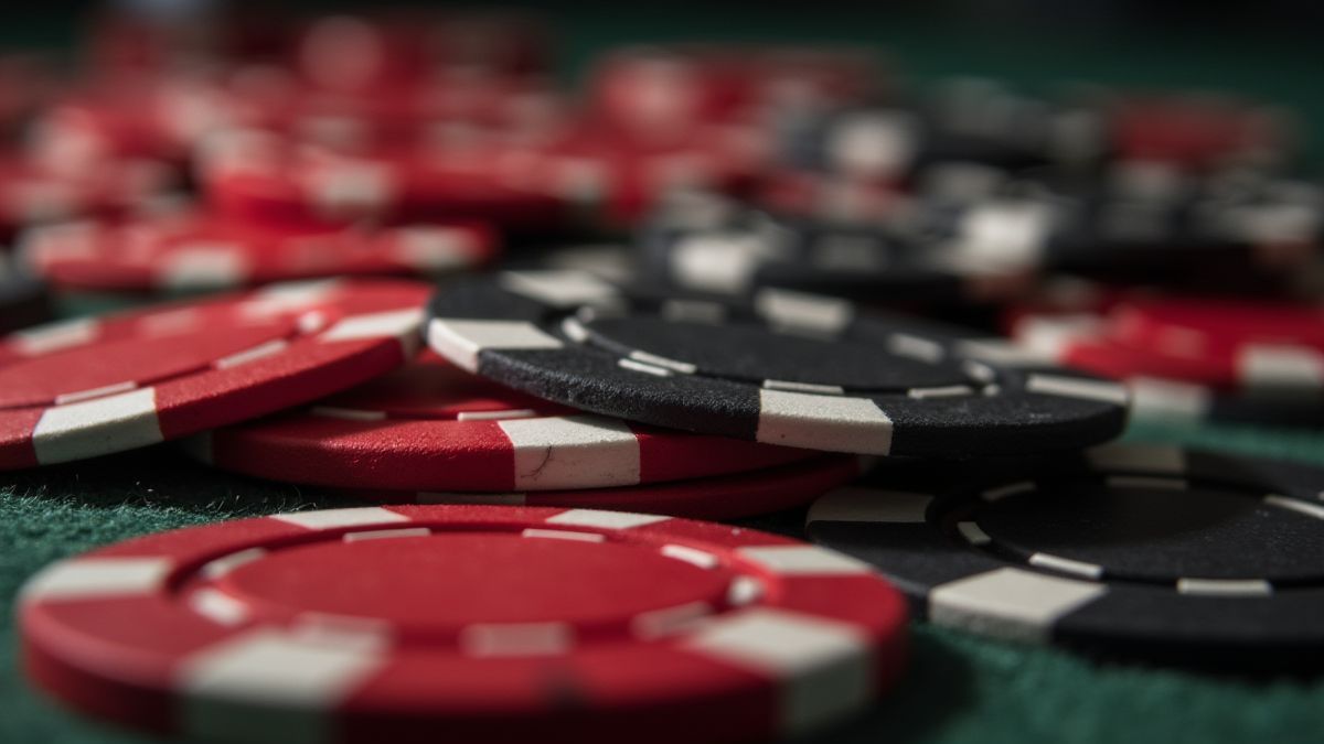 Nahaufnahme von roten und schwarzen Pokerchips auf einem Tisch.