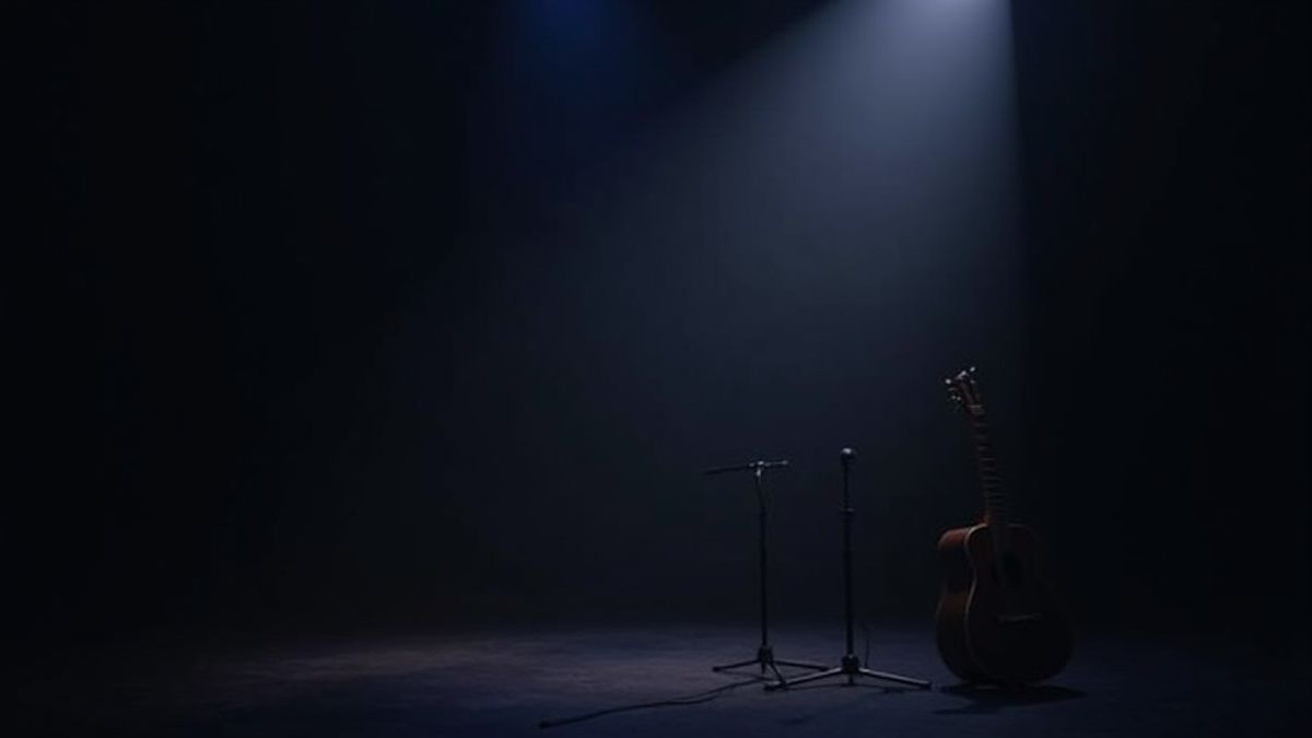 Eine dunkle Konzertbühne mit einer Gitarre und einem Mikrofon unter den Scheinwerfern.