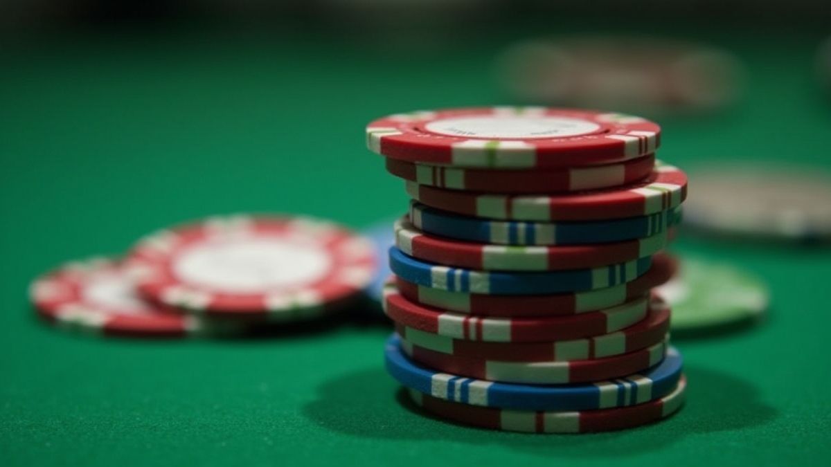Montagne de jetons de casino avec différentes dénominations sur une table verte.