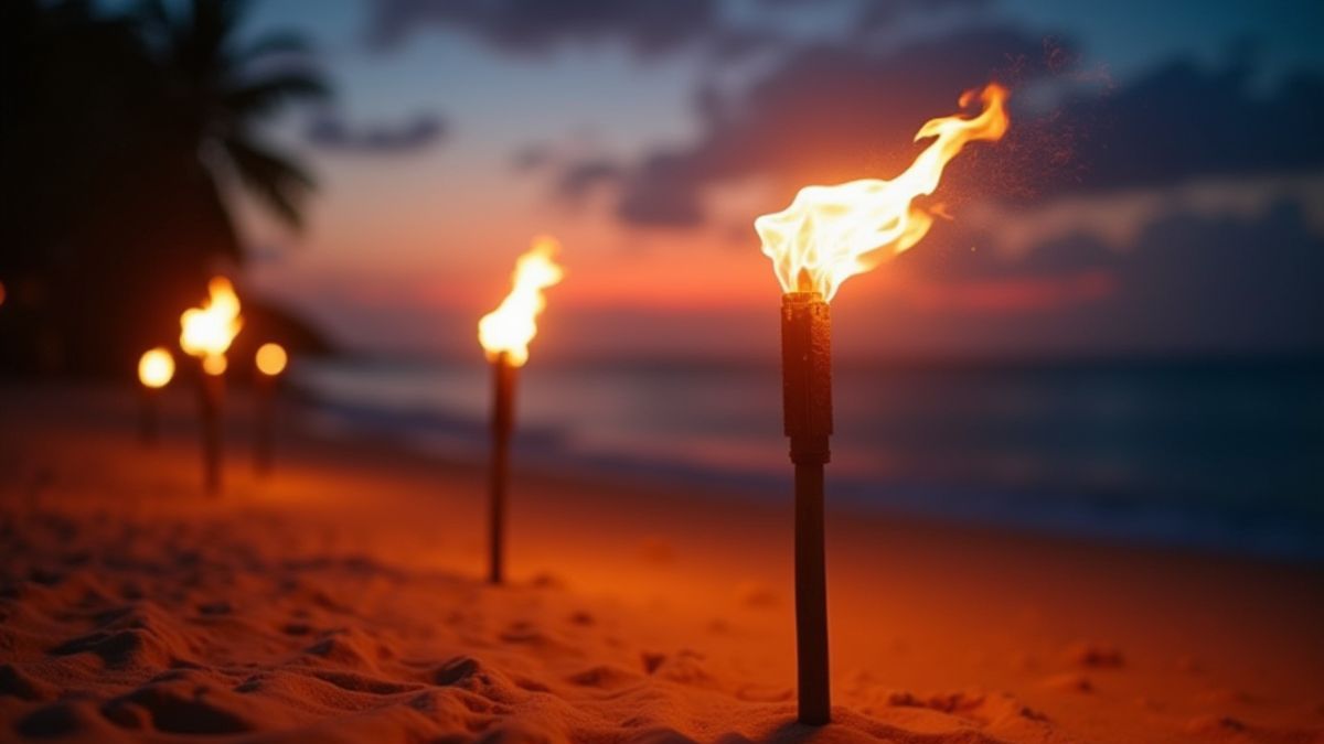 Tiki torches lighting up a tropical beach at sunset.